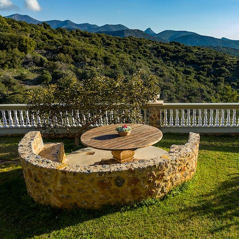 Sip a cocktail around the stone bench as you watch the sun dip behind the hills