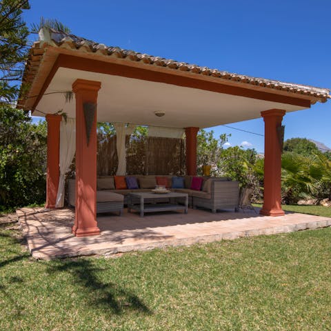 Relax under the towering stone pergola