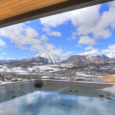Relax in the hot tub overlooking snow-capped mountains
