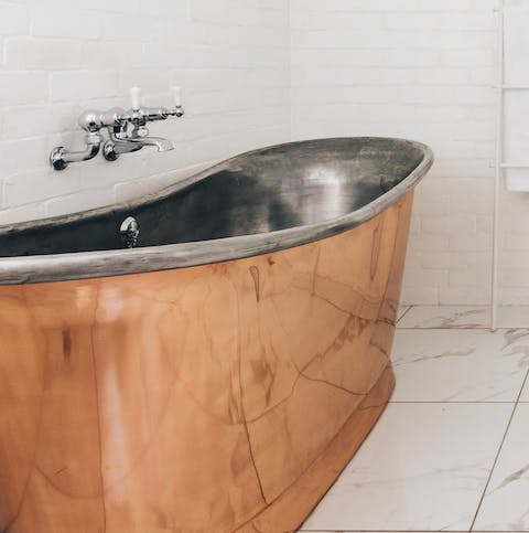Treat yourself to an indulgent soak in the handsome copper bathtub