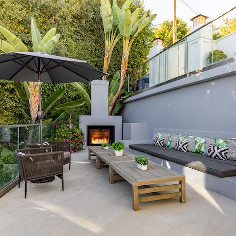 Get cosy around the outdoor fireplace as the sun sets