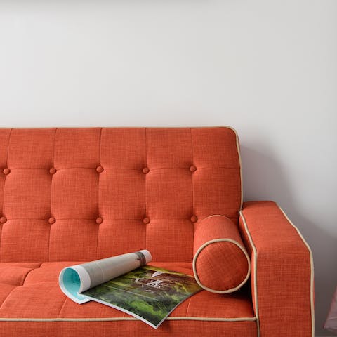 Snuggle up on the bright orange sofa with a good book