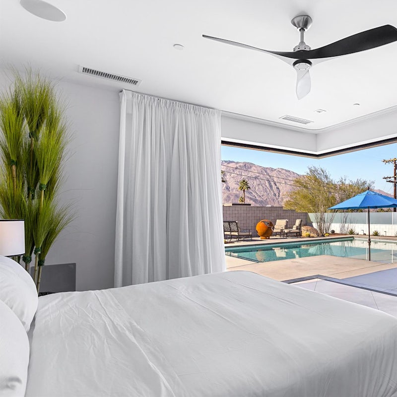 Indulge in a morning coffee in bed, feeling the gentle breeze through the glass doors