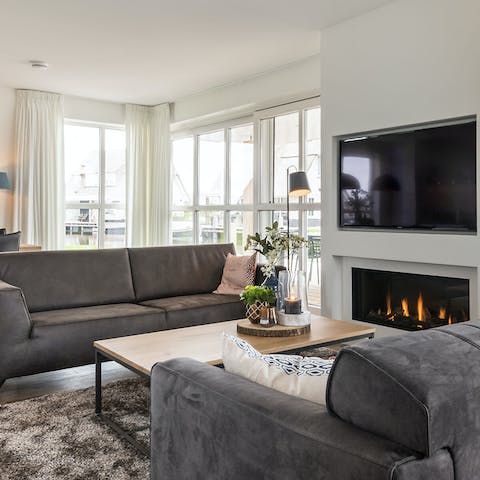 Settle in for a cosy night getting snug on the sofa and watching the smart TV while the fireplace crackles beside you 