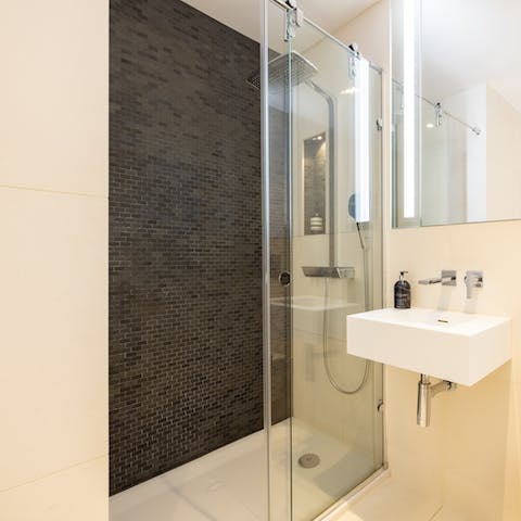Relax and unwind with a soak beneath the rainfall shower