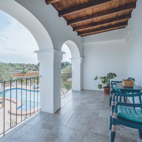 Sit out on the balcony overlooking the pool and surrounding landscape