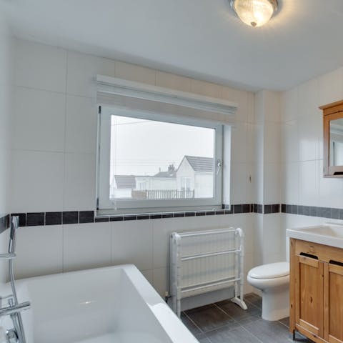 Sink back in steamy water and relax in the boxy white bathtub