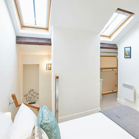 Wake up beneath skylight windows in a king-sized bed with a memory foam mattress