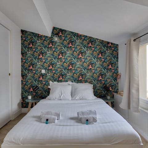 Fall asleep in the comfortable bed, backed by beautiful tropical wallpaper