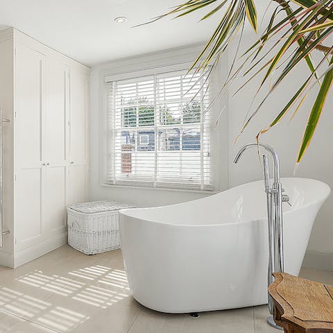 Treat yourself to an indulgent bubble bath in the sleek freestanding tub