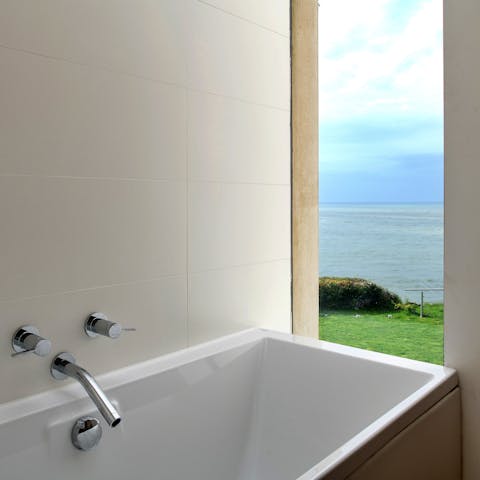 Soak in the bath as you drink in the sea views