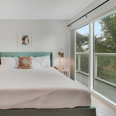 Wake up to palm fronds at your window in the bright bedroom