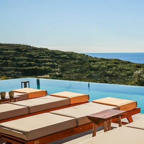Relax on plush sun loungers with perfect sea views