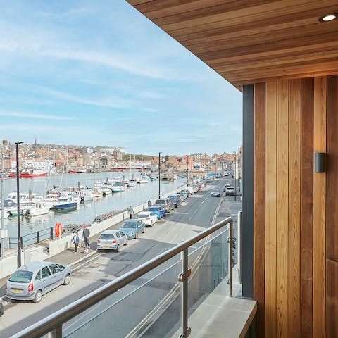 Watch the boats bobbing in the water from your private balcony