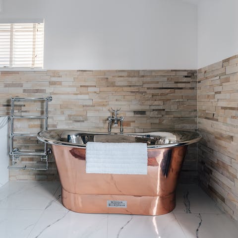 Treat yourself to an indulgent soak in the gleaming copper bathtub