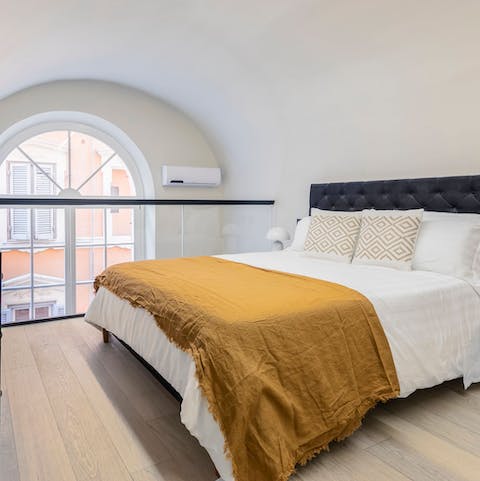 Wake up in the mezzanine bedroom to views through the arched window