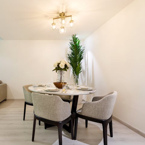 Gather around the chic dining table beneath the warm-toned light fixture