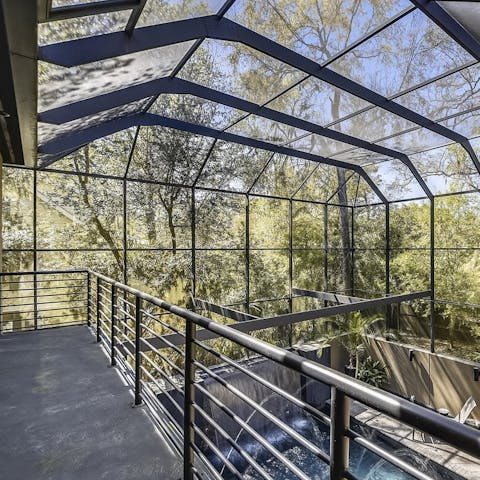 Step out from the master suite and look down on the pool and out at the surrounding nature 