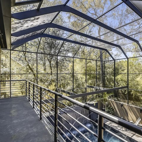 Step out from the master suite and look down on the pool and out at the surrounding nature
