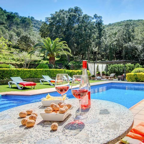 Sample some local snacks and wine by the pool after a refreshing swim