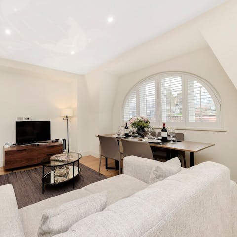 Sit down to an elegant meal framed by the living room's arched window