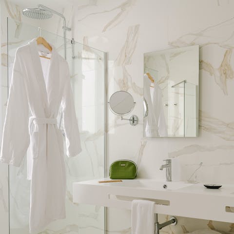Feel anew beneath the rainfall shower of the slick, marble-clad bathroom 