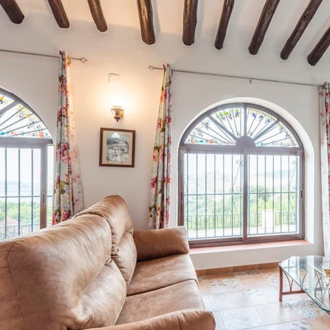Relax on your sumptuous sofa and enjoy stunning views through the arched window
