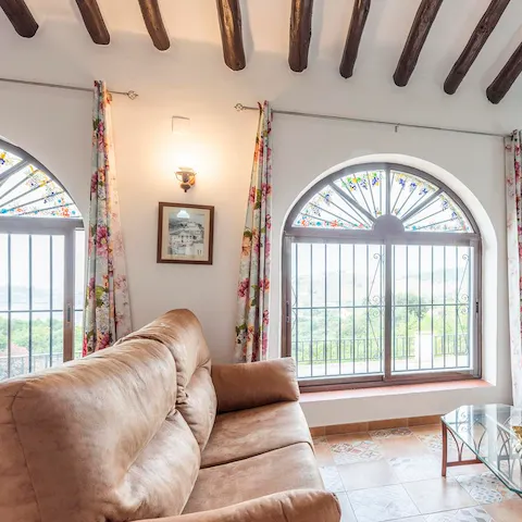 Relax on your sumptuous sofa and enjoy stunning views through the arched window