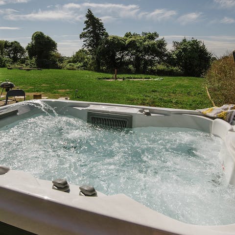 Soak in the private hot tub while taking in the endless green views