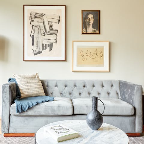 Get comfy on the stylish velvet sofa with a good book and a mug of coffee