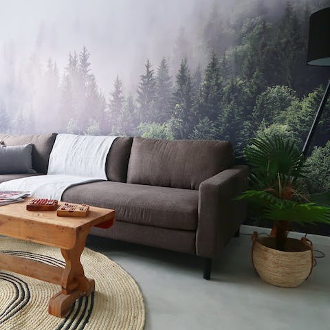 Sink into the comfortable couch surrounded by plants and the forest backdrop