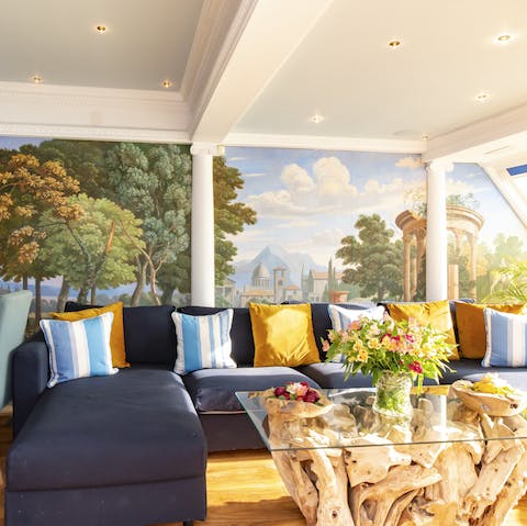 Sink into the plush sofa, surrounded by painted murals and Greek columns as sunlight floods the living space