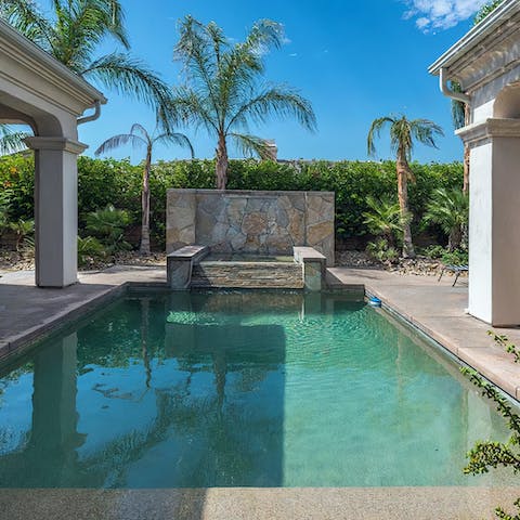 Swim in the pool with a tropical backdrop