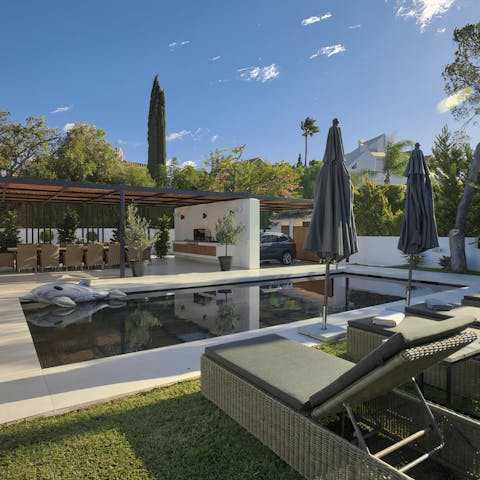 Relax around the swimming pool in the leafy green garden 