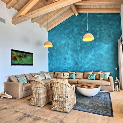 Get together on the huge corner sofa by the wall that shimmers like the sea