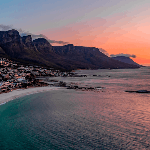 Stroll along the sands of Camps Bay Beach at sunset, a short drive away
