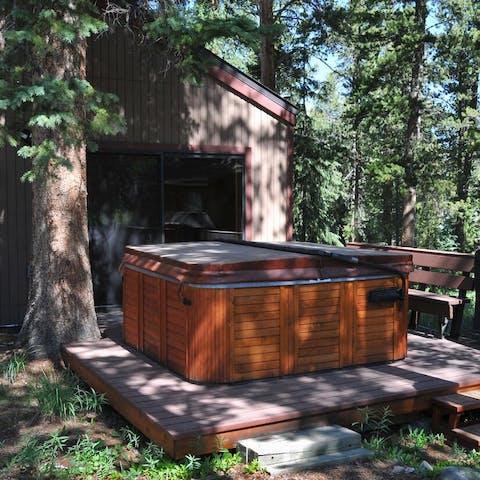 The outdoor wooden hot tub next to an open air grill