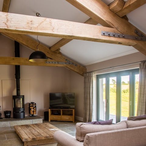 Cosy up by the wood-burning stove, beneath the impressive oak beams