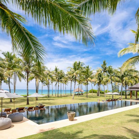 Spend lazy days drifting between the pool and your private beach