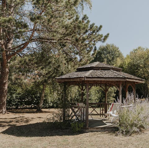 Find shade under the pergola with a glass of chilled wine in hand