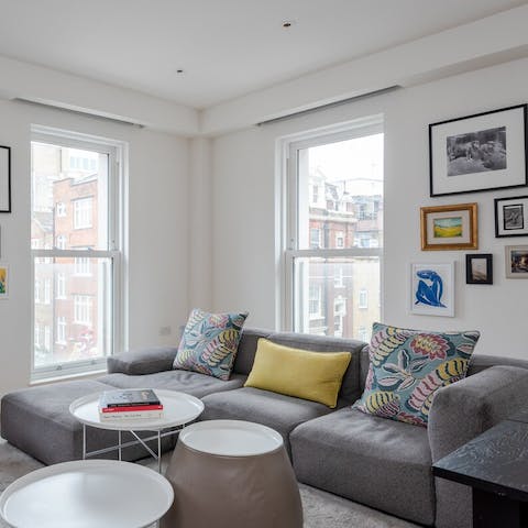 Cosy up on the sofa while taking in Central London views from the living room's tall windows