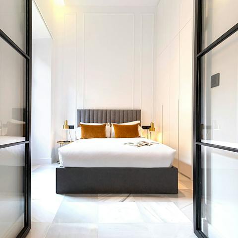 Enter the bedroom through the beautifully modern glass double doors
