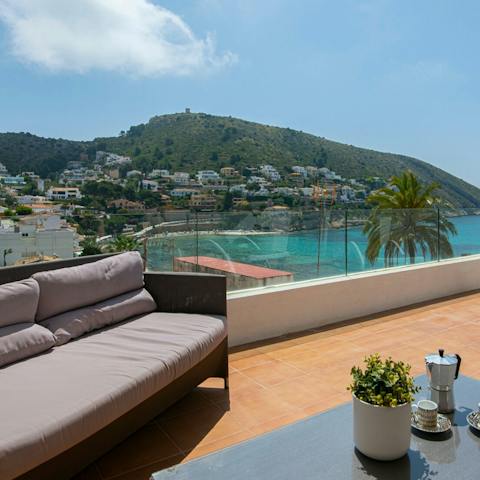 Sip a glass of wine and soak up views of El Portet Bay from your enviable vantage point