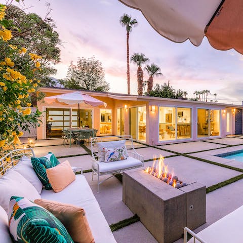 Gather around the fire pit as the sun sets against the palm trees