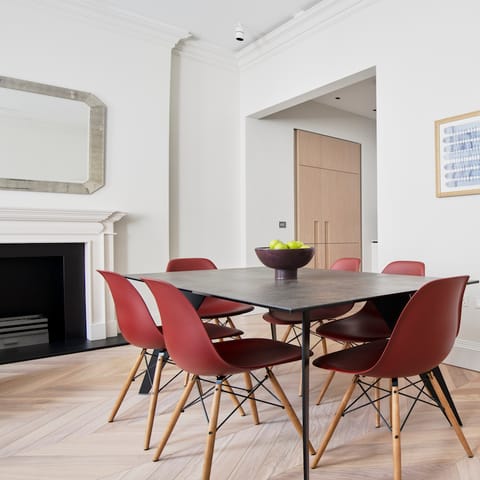 Dine around the table on the red Eames chairs