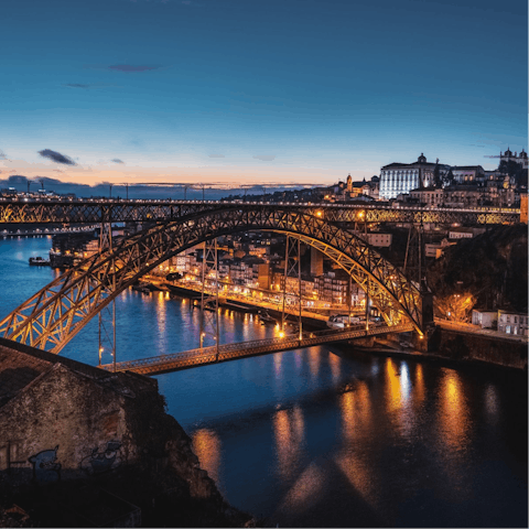 Take some  snaps of the stunning D. Luís I Bridge at night, a five-minute walk