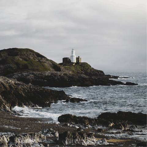 Walk along the rugged coastal path to reach the Mumbles Lighthouse