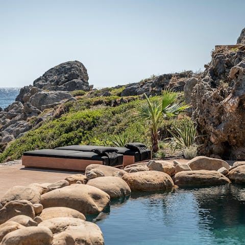 Dive into the natural-style pool and dry off on one of the sea-facing loungers
