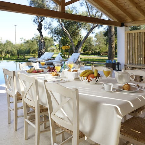 Set up for meals in the lofty outdoor dining area with its wooden roof