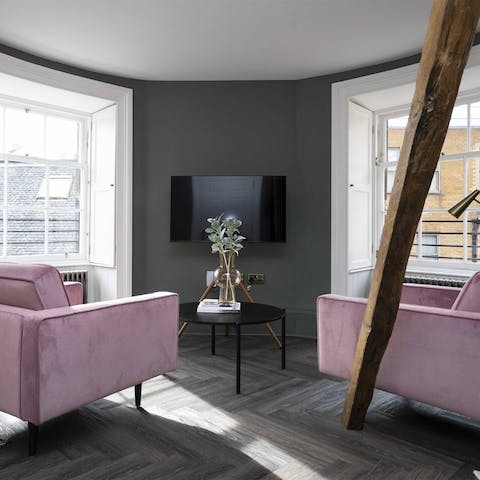 Make yourself at home on the blush pink armchairs after a day of sightseeing